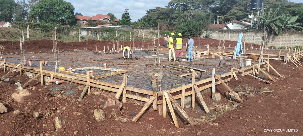 Construction team preparing reinforcement and formwork for a foundation slab