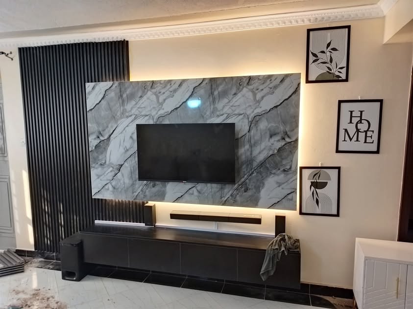 Marble-look entertainment wall with integrated lighting and dark slat detail